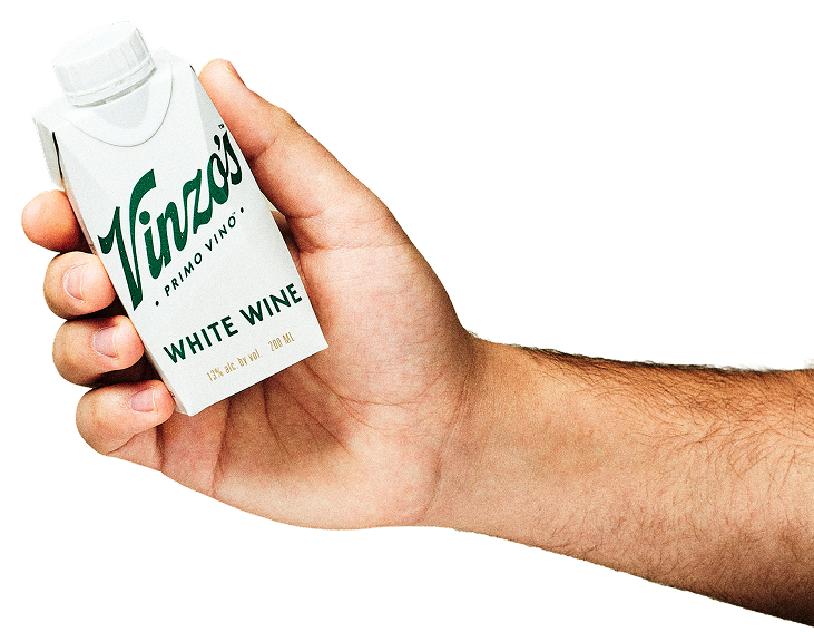 A person's hand holding a 500ml carton of Vinzo's Primo Vino White Wine.