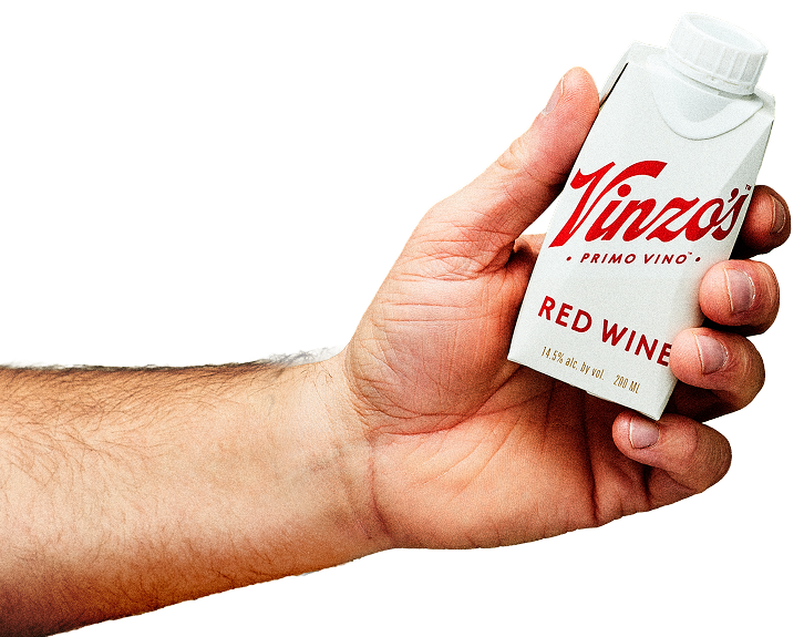 A person's hand holding a white 500ml carton of Vinzo's Primo Vino Red Wine.